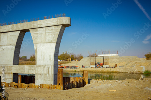 Huge pole in foundation with metal piles, construction of concrete-reinforced bridge pillars at building site