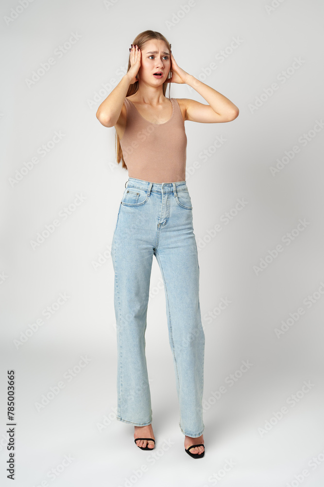 Young woman is in shock or surprise of the news against gray background Young woman is in shock or surprise of the news against gray background