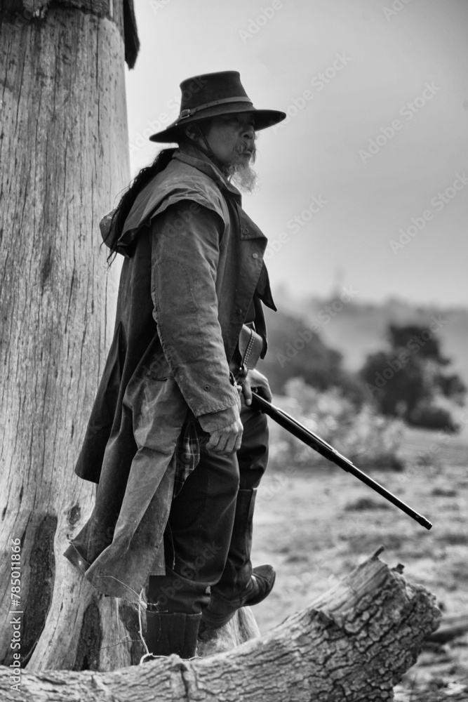 Black and white photo of a Mexican cowboy standing with gun in hand Black and white photo of a Mexican cowboy standing with gun in hand