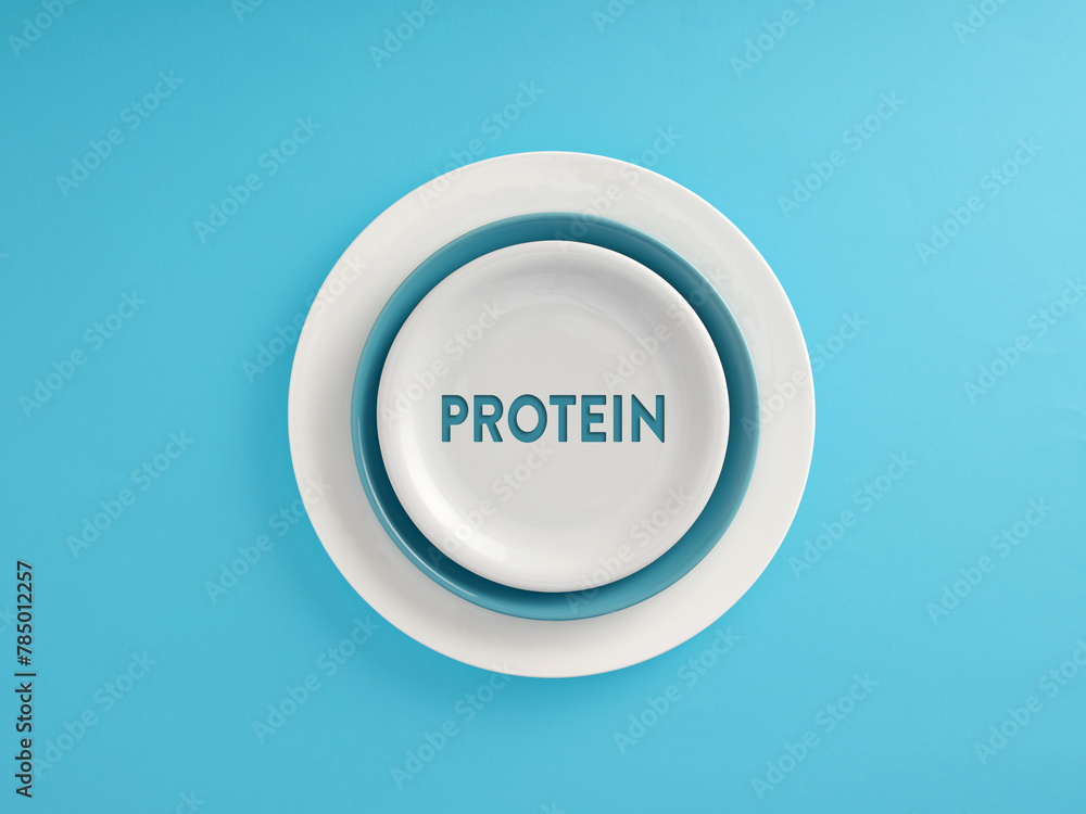 The word Protein written on a plate over blue background. Healthy nutrition concept. The word Protein written on a plate over blue background. Healthy nutrition concept.