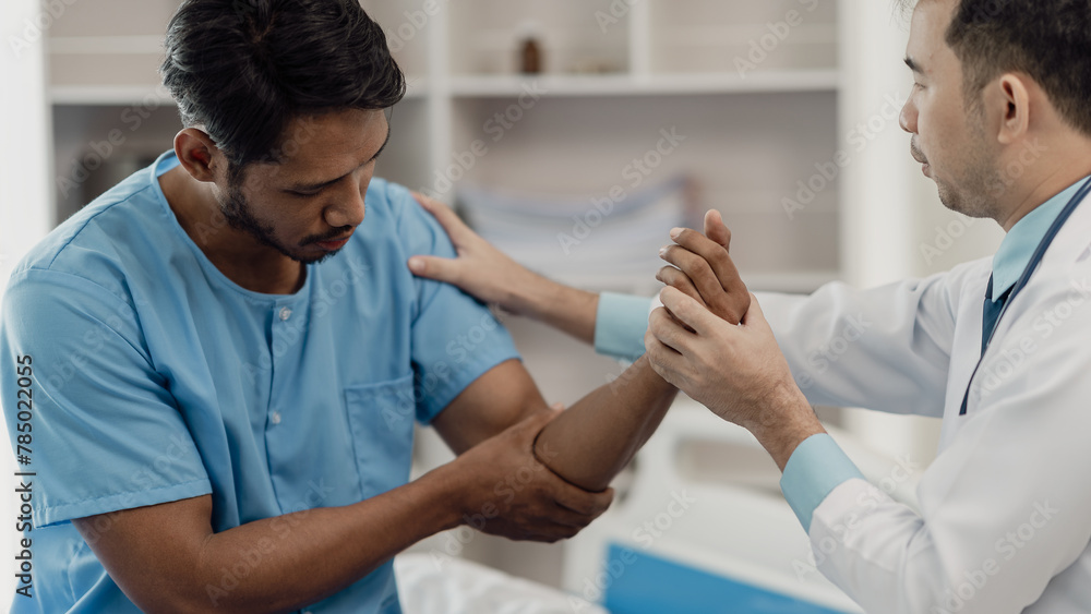 Obraz premium Physical therapist helping a patient while stretching his legs on a bed in a clinic or hospital. Young man attends a physiotherapy course on muscle weakness pain. and heel pain with elastic