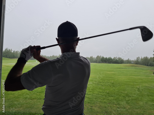 Man Swinging Golf Club at Golf Course