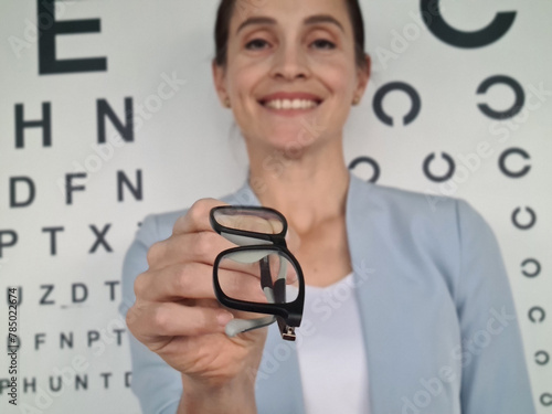 Fotografi Woman Holding Up a Pair of Glasses
