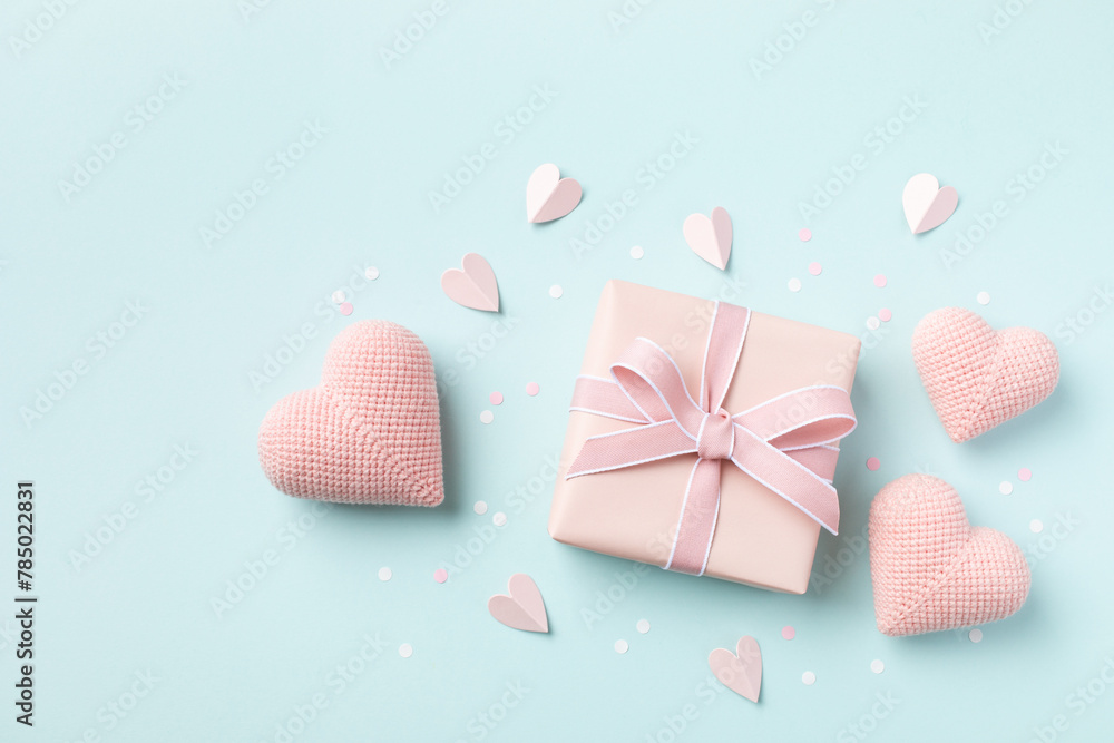 Birthday, Woman or Mothers Day greeting card. Pink hearts and gift box on blue pastel table top view. Flat lay. Birthday, Woman or Mothers Day greeting card. Pink hearts and gift box on blue pastel table top view. Flat lay.