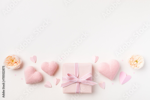 Festive background for Birthday, Woman or Mothers Day. Pink hearts, rose flowers and gift box on table top view. Flat lay.