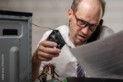 Angry office worker with broken computer cooler phoning tech support for help, Repairing a broken computer makes the man visibly upset