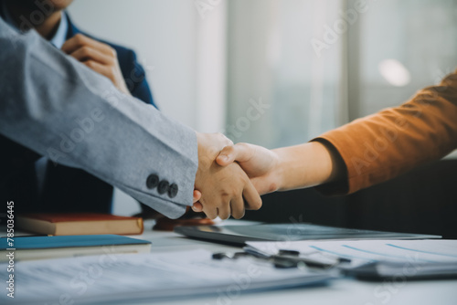 Businessman shaking hands to seal a deal with his partner lawyers or attorneys discussing a contract agreement.