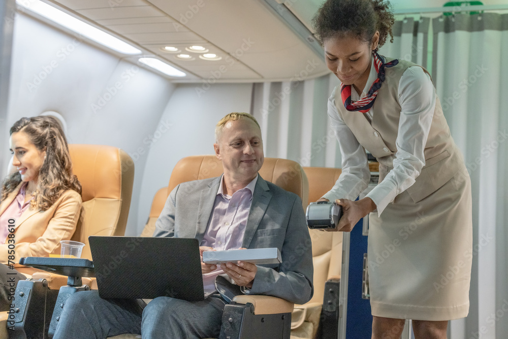 Business Travelers Making Purchases With a Female Flight Attendant on Board Business Travelers Making Purchases With a Female Flight Attendant on Board