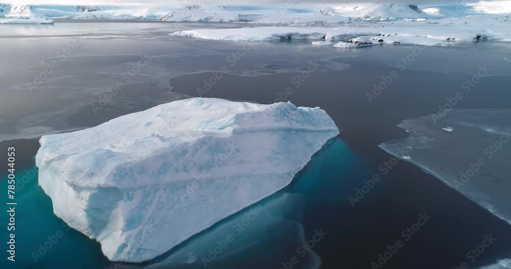 Aerial big iceberg in Antarctica frozen polar ocean. Ice floe drift cold snow covered sunset landscape. Natural beauty of towering glacier. Antarctic polar winter. Arctic winter scene drone panorama Aerial big iceberg in Antarctica frozen polar ocean. Ice floe drift cold snow covered sunset landscape. Natural beauty of towering glacier. Antarctic polar winter. Arctic winter scene drone panorama