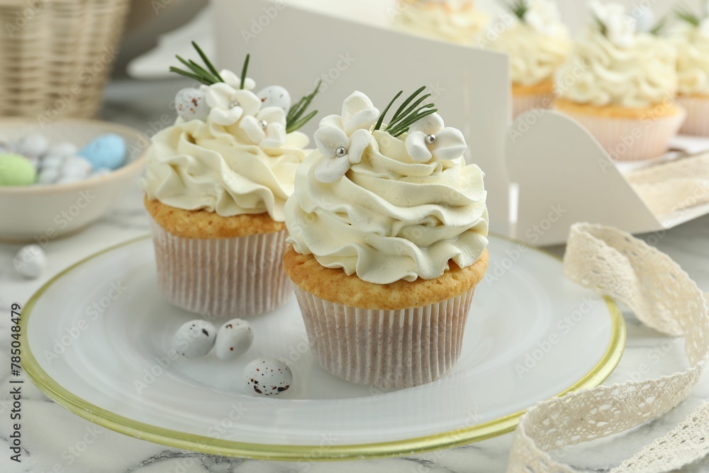 Tasty Easter cupcakes with vanilla cream on white marble table Tasty Easter cupcakes with vanilla cream on white marble table