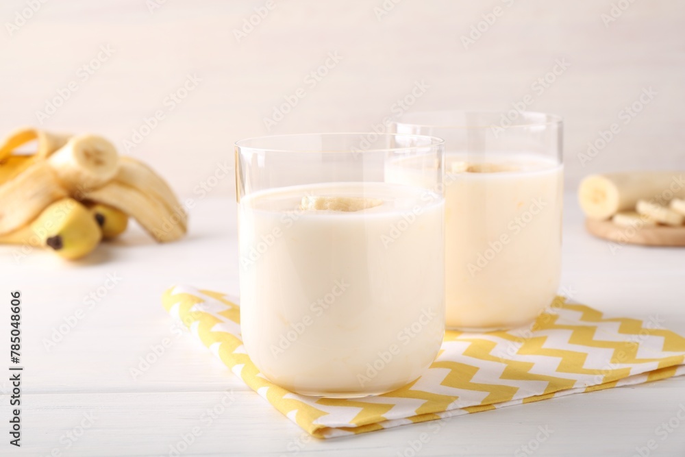 Tasty yogurt and banana in glasses on white wooden table, closeup Tasty yogurt and banana in glasses on white wooden table, closeup