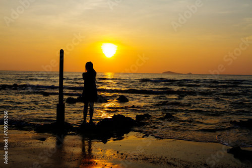 Woman happy look sunrise with silhouette at beach