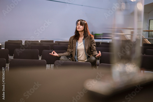 Mature professor meditating in lecture hall photo