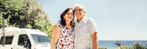 Affectionate Senior Couple Standing by Camper Van on Sunny Day