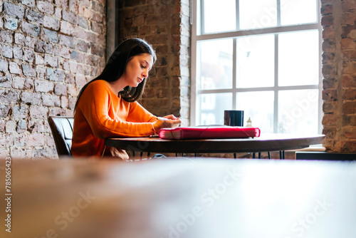 Young woman concentrating on studies at cafe photo