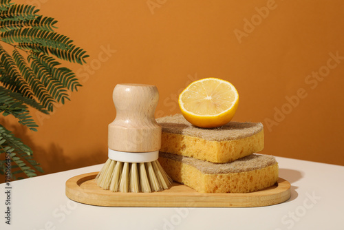 Sponges, brush and lemon on brown background © Atlas