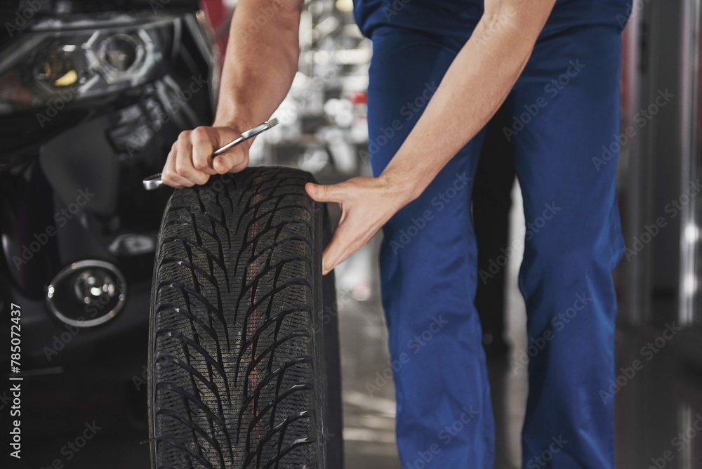 close-up-mechanic-showing-ok-gesture-with-his-thumb-while-holding-wrench