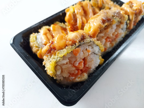 Photo of sushi with sauce on top. This food is a typical Japanese food. Sushi is made from rice with the addition of seafood, eggs and fresh vegetables