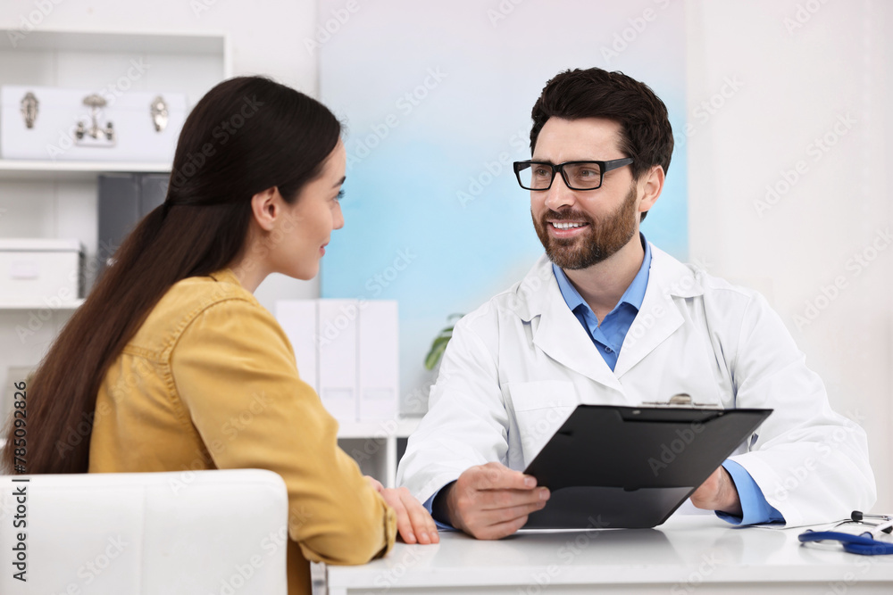 Doctor consulting patient during appointment in clinic Doctor consulting patient during appointment in clinic