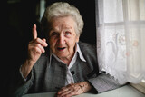 Photograph of a mature lady with a significantly raised index finger.