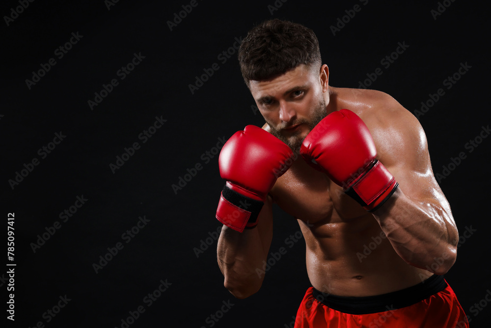 Man in boxing gloves on black background. Space for text