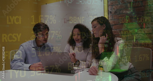 Image of stock market data processing over three diverse colleagues discussing over laptop