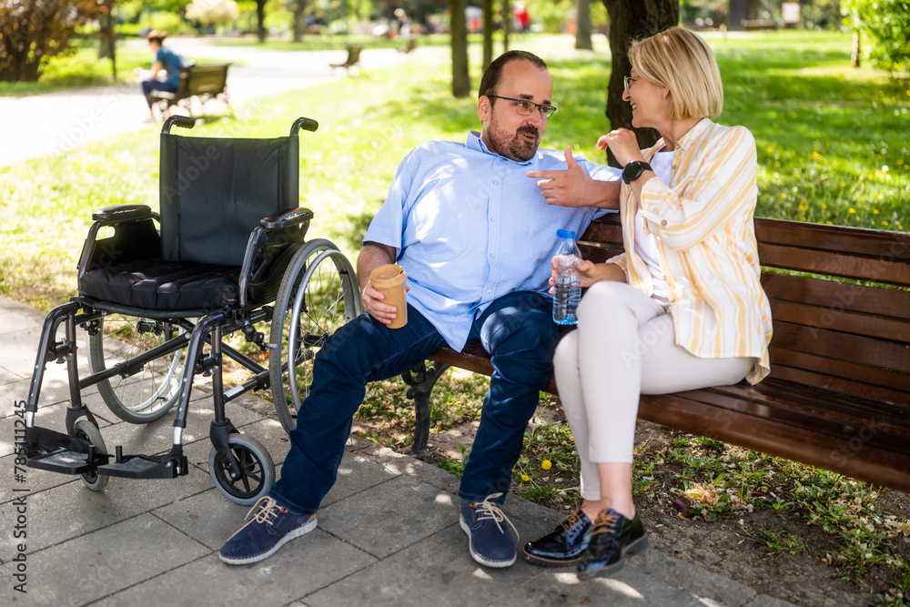 Man in wheelchair is spending time with his mother in park. Man in wheelchair is spending time with his mother in park.