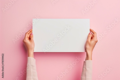 mockup womans hands holding a blank paper banner on a pastel pink background