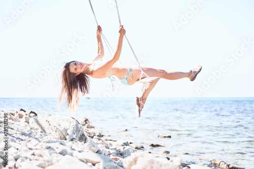 Young woman on the swing at the beach of Black sea