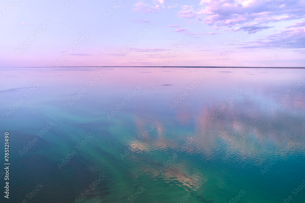 A lake reflecting a purple sky at dusk, creating a mesmerizing natural landscape