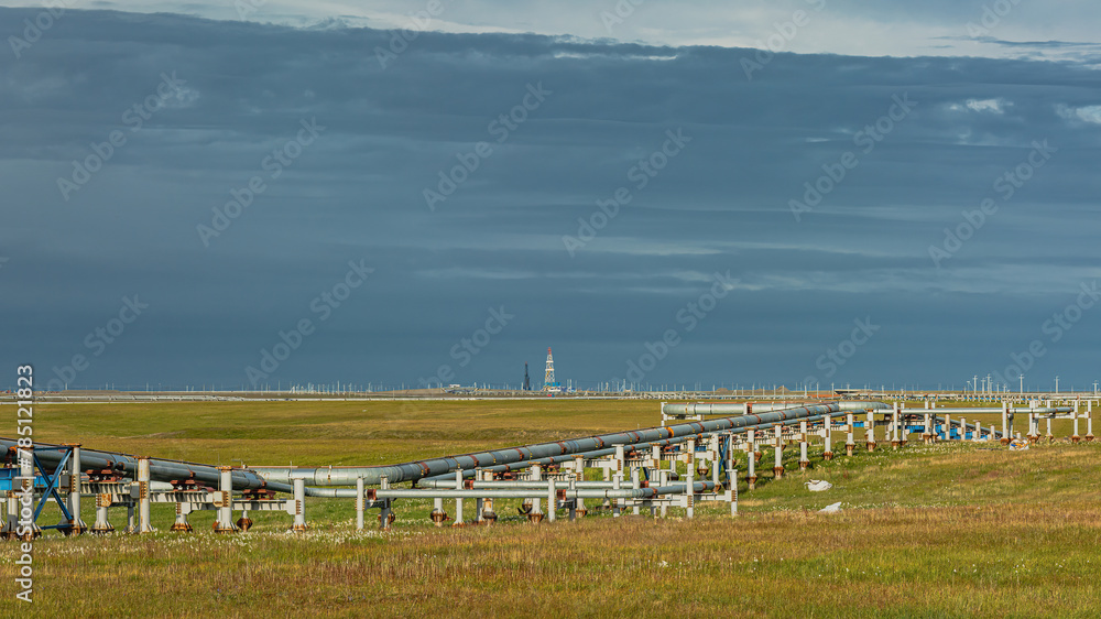 Infrastructure for oil and gas production and transportation. Northern field. Arctic nature. Pipelines. Drilling rig on the horizon