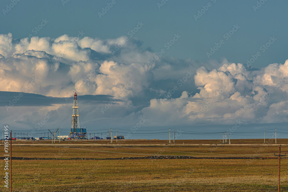 Landscape of the northern tundra in summer. On the horizon the infrastructure of drilling wells at an oil and gas field. Beautiful textured sky Landscape of the northern tundra in summer. On the horizon the infrastructure of drilling wells at an oil and gas field. Beautiful textured sky