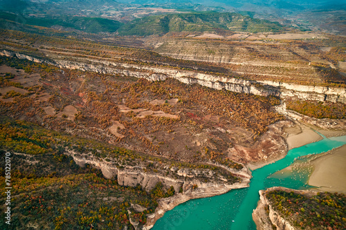 Aerial view of river cutting through mountainous terrain and lush trees