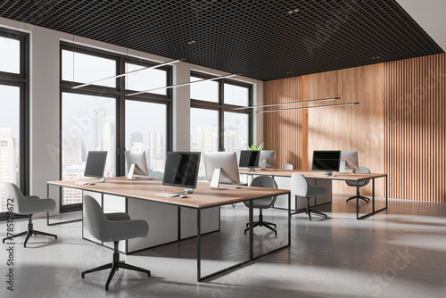 Modern coworking interior with table and pc desktop, panoramic window