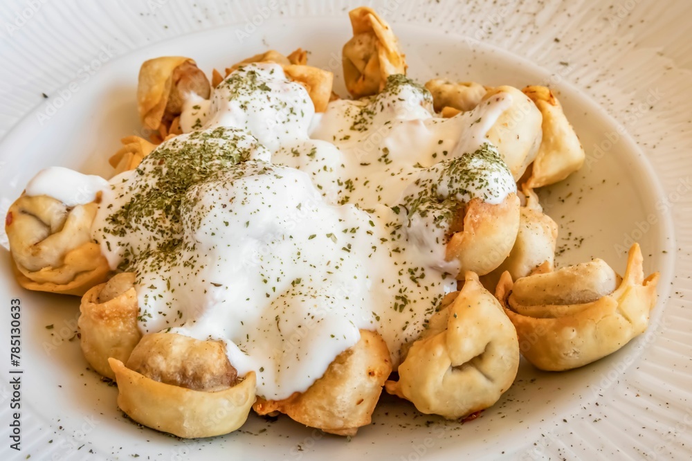 Bowl of Manti in a plate on the table Bowl of Manti in a plate on the table
