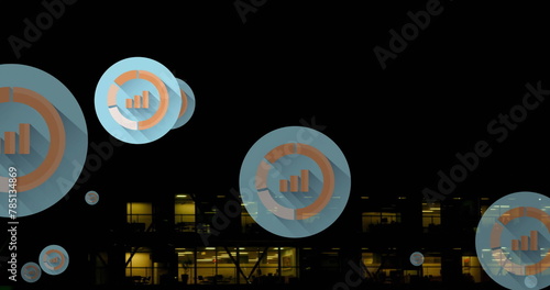 Image of multiple graph icons over aerial view of modern building against night sky