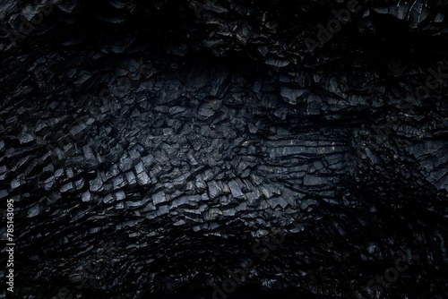 Closeup of black textured beautiful volcanic lava rocks in a dark Cape