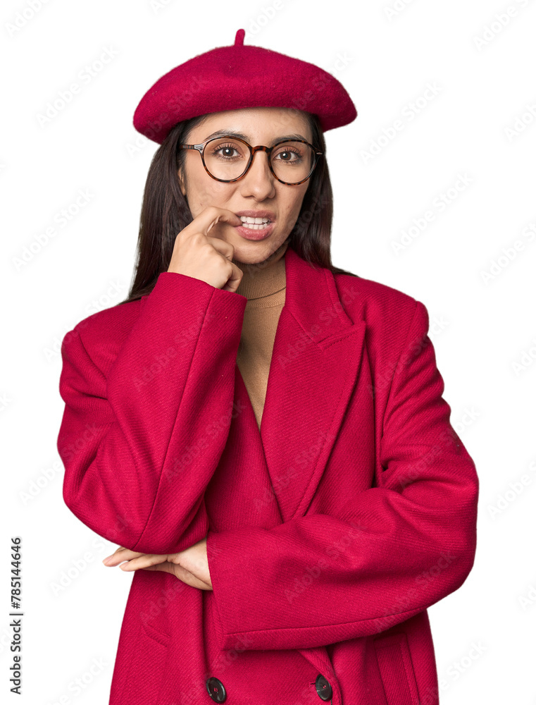 Stylish young Caucasian woman in red trench coat and beret on studio background relaxed thinking about something looking at a copy space. Stylish young Caucasian woman in red trench coat and beret on studio background relaxed thinking about something looking at a copy space.