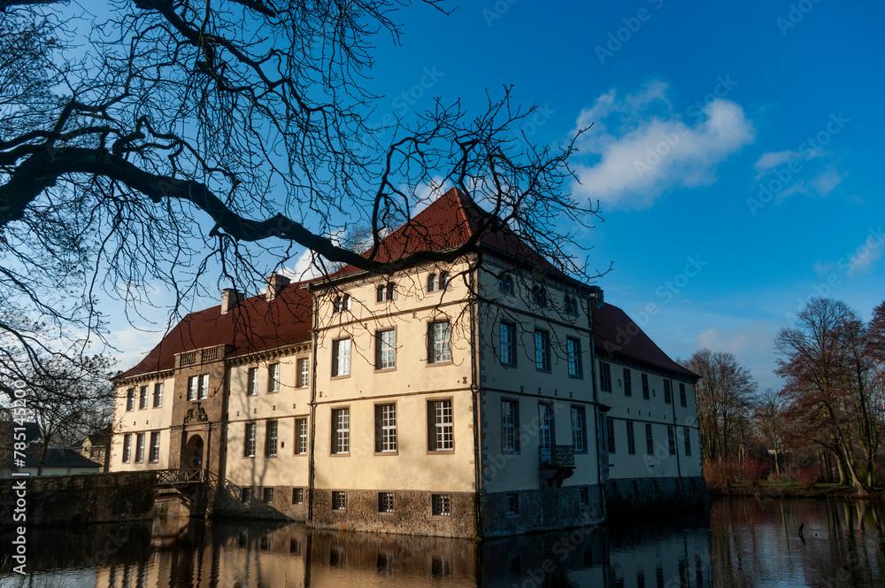 Obraz premium Schloss Strunkede grom the bare branches on a sunny morning in Herne