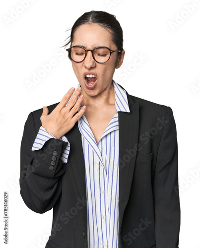 Confident young Caucasian businesswoman on studio background yawning showing a tired gesture covering mouth with hand.