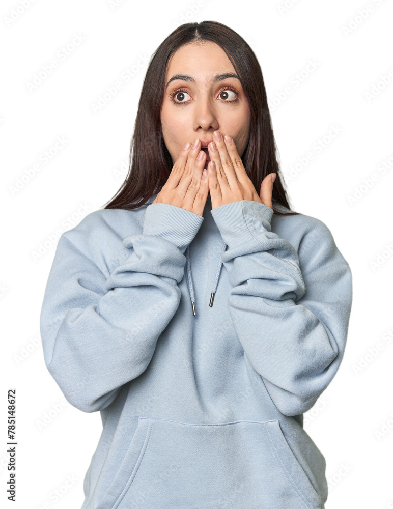 Modern young Caucasian woman portrait on studio background shocked, covering mouth with hands, anxious to discover something new.