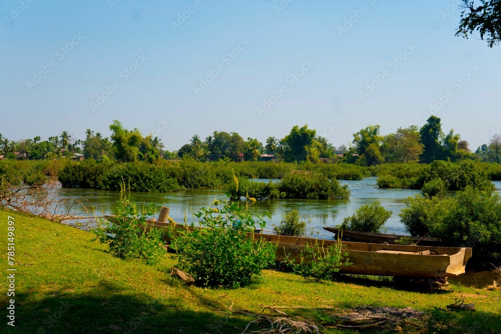 Obraz premium Wooden boat parked in the shore of a lake during daytime