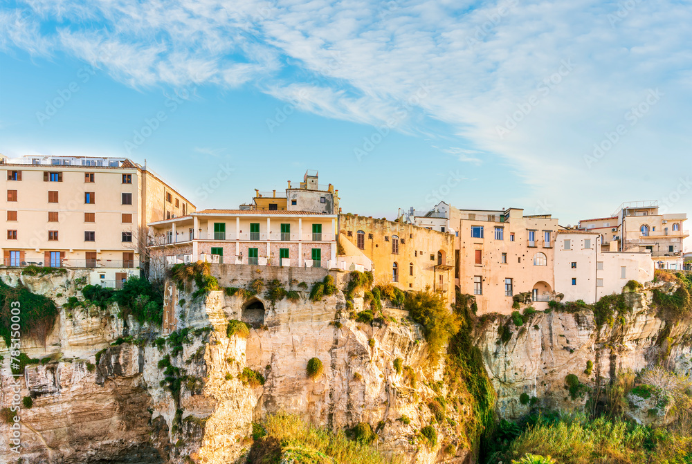 Obraz premium scenic travel landscape of beautiful historic town Tropea in Italy with old antique buildings, vintage houses on a high rock cliff above sea and amazing blue sky on background
