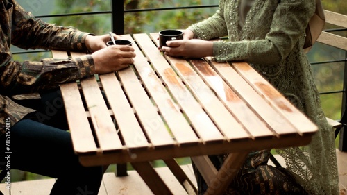 Couple sitting on wooden table enjoying time with a drink