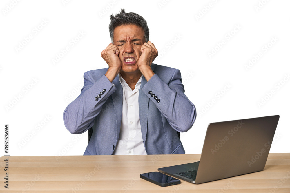 Elegant businessman at desk with laptop crying, unhappy with something, agony and confusion concept. Elegant businessman at desk with laptop crying, unhappy with something, agony and confusion concept.