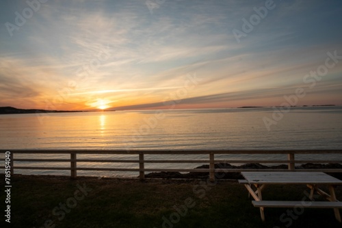 Wallpaper Mural Wooden table and bench situated on a beach with a beautiful orange and pink sky in the background Torontodigital.ca