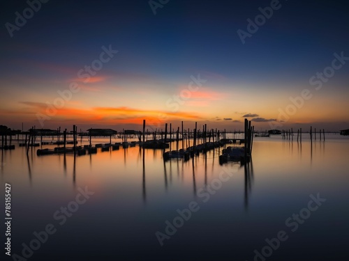 Aerial view of a bright sunset sky over wooden poles in the clear Songkhla Lake,Thailand