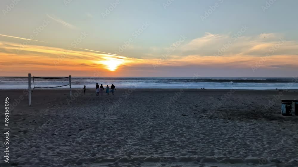 Pan across Manhattan Beach at sunset, tourists enjoying coastal charm and golden hues Pan across Manhattan Beach at sunset, tourists enjoying coastal charm and golden hues