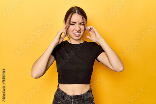 covering ears with fingers, stressed and desperate by a loudly ambient.