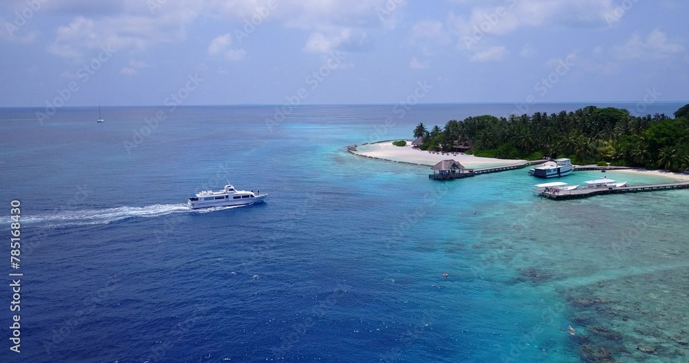 Obraz premium Aerial view of boats near a small island with trees in Maldives